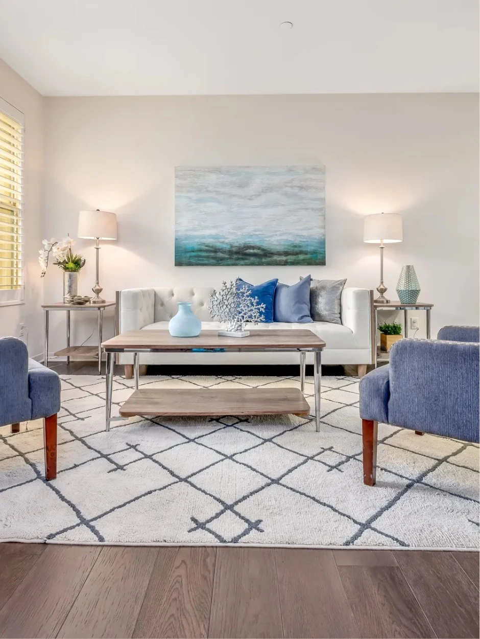 Staged living room with neutral sofa and soft textiles by STAGED.
